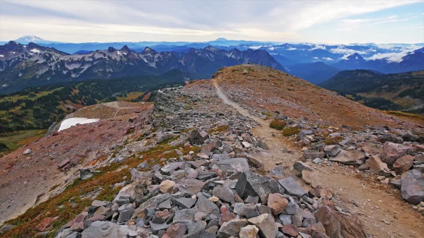 panoramic view from Panorama Point on the Skyline Trail in Mount Rainier National Park, Washington. The image captures the rugged mountain landscape, distant peaks like Mount Adams and Mount St. Helen