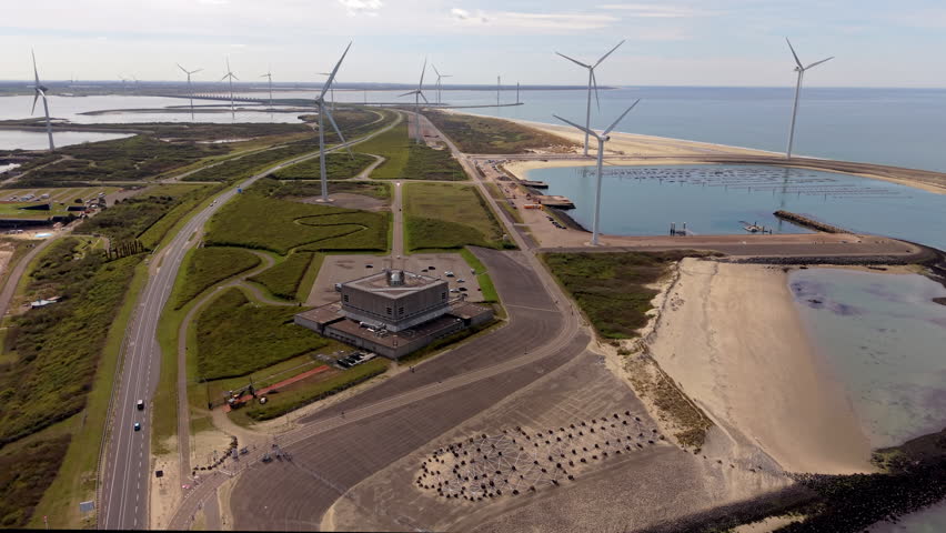 Aerial view of coastal wind turbines, sandy beaches, waterways and modern infrastructure, showcasing renewable energy, sustainable landscape and scenic shoreline environment.
