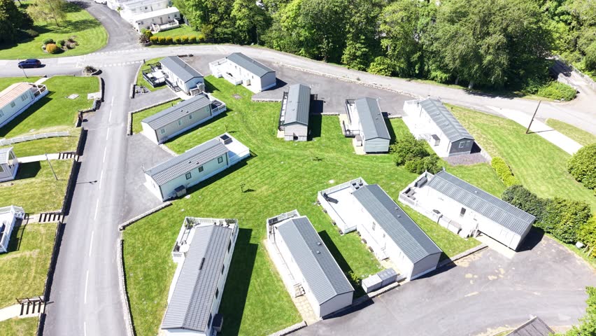 A warm aerial scene showing caravans near woodland vegetation.