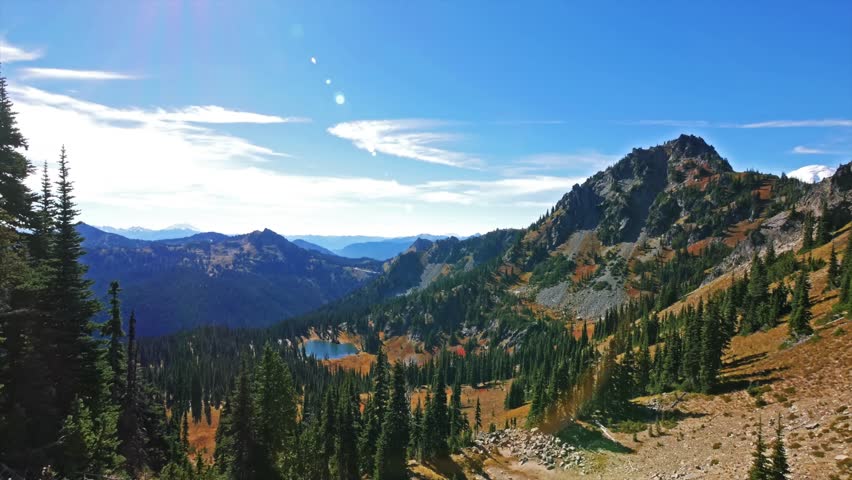 footage of the Sheep Lake Trail near Chinook Pass, showcasing a crystal-clear subalpine lake nestled in a mountain basin with sweeping vistas of the Pacific Crest Trail (PCT) and surrounding evergreen