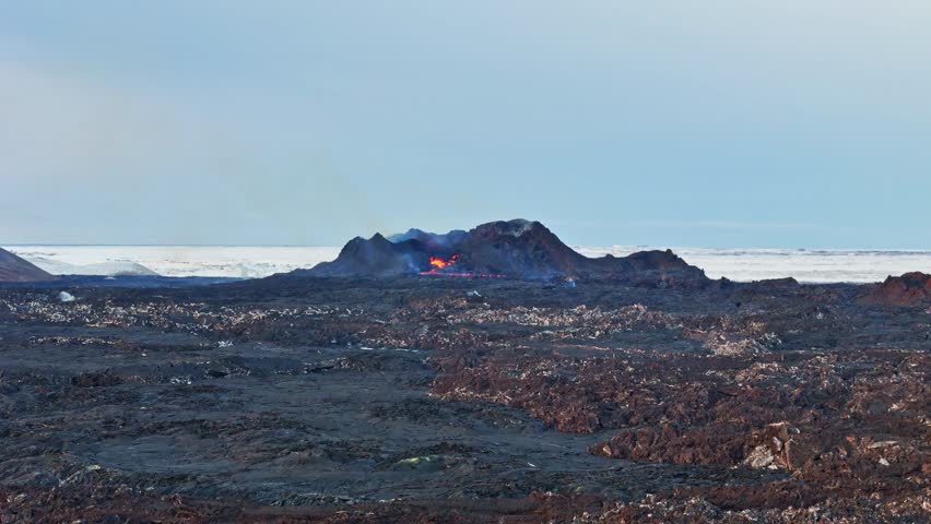 Aerial view of Sundhnukur Volcano with its smoking crater and vast dark lava fields under a pale sky in Grindavik, Grindavikurbaer, Iceland.