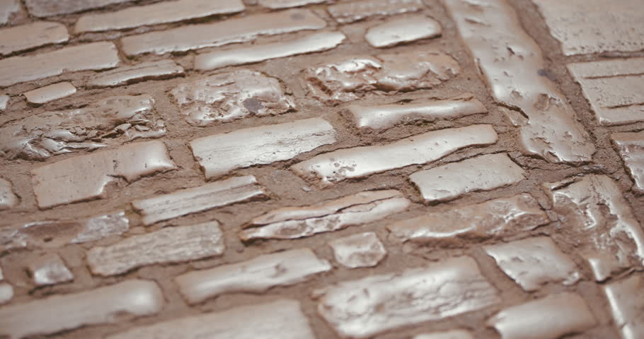 Close-up of worn stone pavement texture in an old town street.