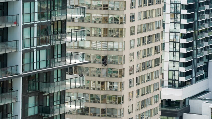 Suspended window washer working on modern high rise building
