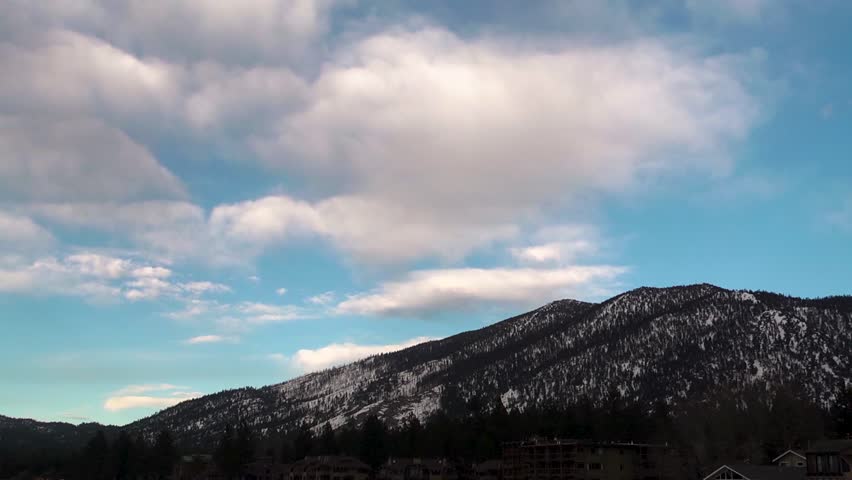Clouds moving over snowy mountains