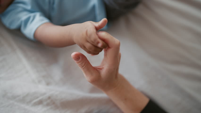 Unconditional love of mother and child, close up view of female and infant hands . Happiness and tenderness of moments, careful black woman spending time with infant girl or boy, family relationship