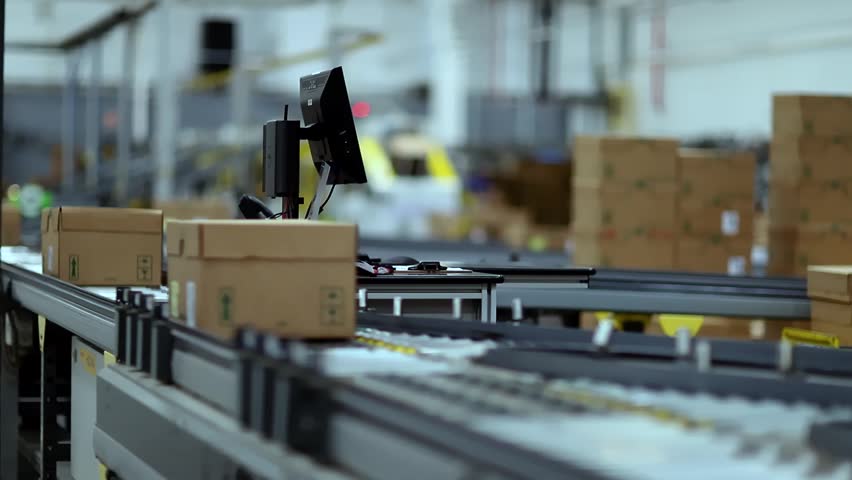 Cardboard boxes on the conveyor belt are isolated. Distribution warehouse. E-commerce, storage, delivery, and packaging service concept. 09-10-2025 