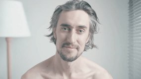 Smiling Joyful Beautiful Young Man in a Bedroom, Displaying Various Facial Expressions in Soft Lighting - Powered by Shutterstock - Get 15% off with code: PIKWIZARD15
