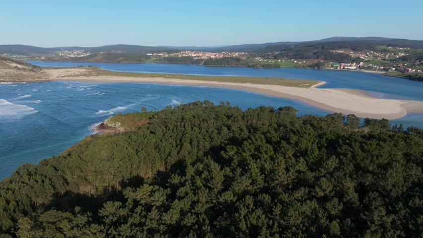 Coastal Estuary Landscape With Dense Forest In Foreground And Sandy Beach In Galicia, Spain. wide aerial shot