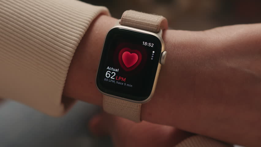 Person checking heart rate on a smartwatch worn on the wrist. Fitness tracking, health monitoring and wearable technology concept. High quality 4k footage