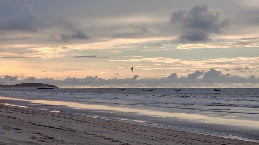 Panoramic View of a Serene Beach at Sunset with Pastel Clouds