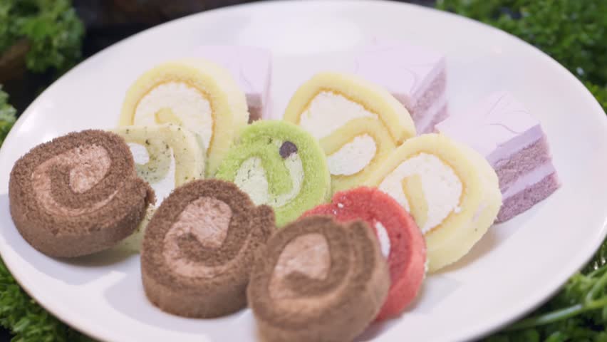 A white round plate holds colorful cakes with various flavors.