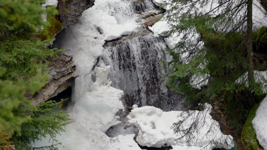 Generic waterfall scene at Johnston Canyon in winter, water falling over icy ledge.