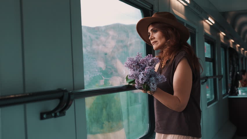 Woman smiles gently, holding purple flowers
