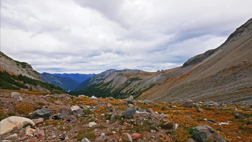 A wide-angle view of the rugged, rocky terrain and vibrant autumn foliage along the Glacier Basin Trail in Mount Rainier National Park, Washington.