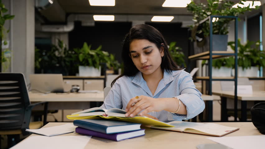 Young Indian student preparing for exams in a university library