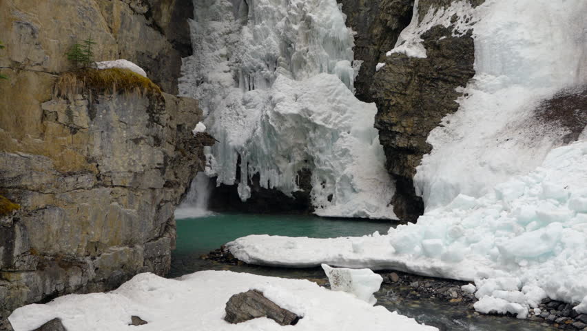 Close-up of Upper Falls with heavy water flow and icy canyon walls in winter.
