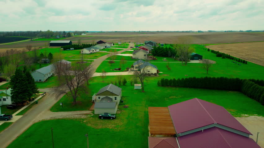 Quiet residential neighborhood in Brandon, Iowa, showing modern homes directly bordering vast agricultural fields.