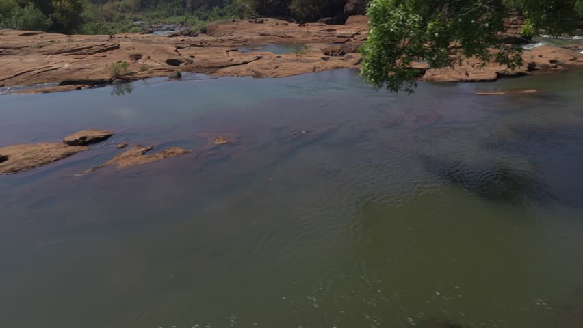 Aerial shot starts low over the river and circles around over the falls looking upstream.