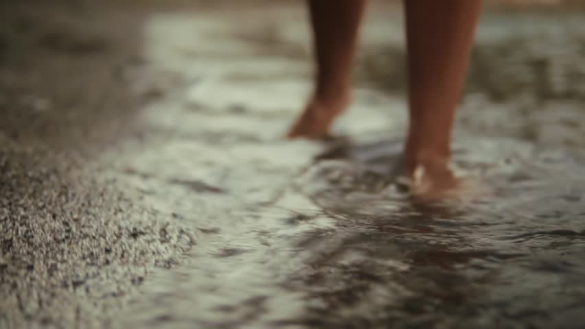 Feet On Shallow Water. Low Angle Shot of Human Sole Stepping Through Wet Ripple Fluid. Moving Bare Leg Splashing Stream Ground. Slow Motion Movement Detail. Outdoor Leisure Activity. Beach Shoreline Journey. Feet Shallow Water Routine. Coastal Walking Process. Marine Ripple Effect. Fluid Motion Presentation. Pedicure Care Theme. Natural Elements Concept. Nature Walking Activity. Barefoot Stepping Process. Wet Ground Surface. Feet Shallow Water View. Feet Bare Sole