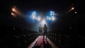 Silhouette of Female Artist Painting on Easel inside Empty Theater Hall - Powered by Shutterstock - Get 15% off with code: PIKWIZARD15