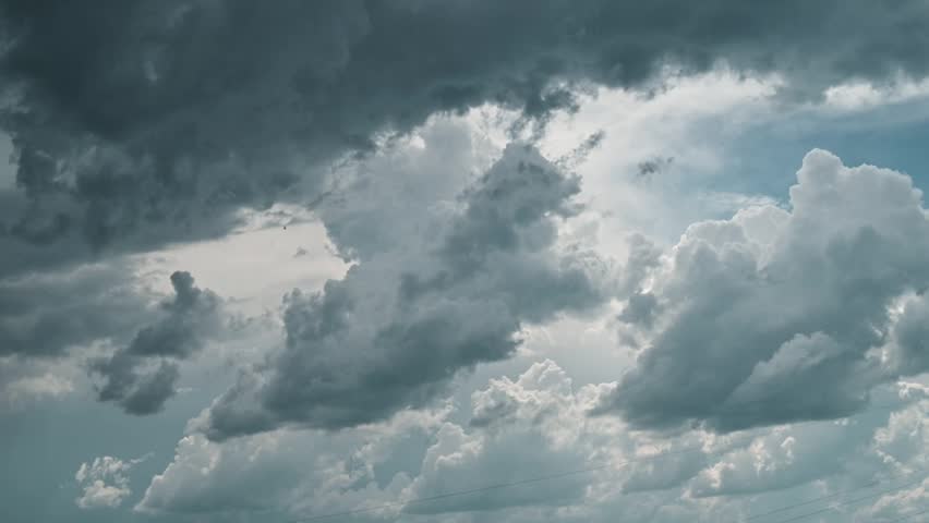 Clouds gather in the sky, showcasing shifting shapes and colors as a storm approaches. The scene conveys a sense of nature