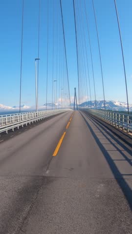 Car driving across a cable stayed bridge in Norway on a sunny day.