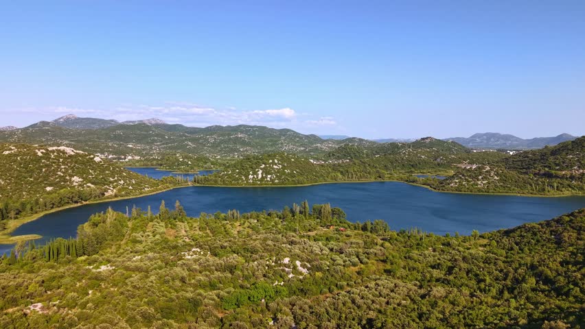 Aerial view of the Bacina Lakes in Croatia, scenic landscape with blue water and green hills under a clear sky