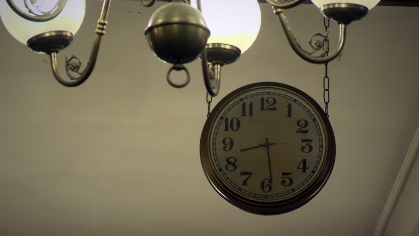 Vintage Railway Clock Hanging Near Antique Bronze Chandelier Lamp in Warm Room - 4K