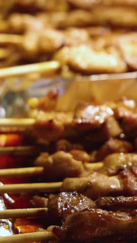 Korean barbecue, Ddakkochi, grilled chicken and pork skewers, variety of different traditional street food selection in Seoul, South Korea, night market with local vendor stalls cooking tasty dishes