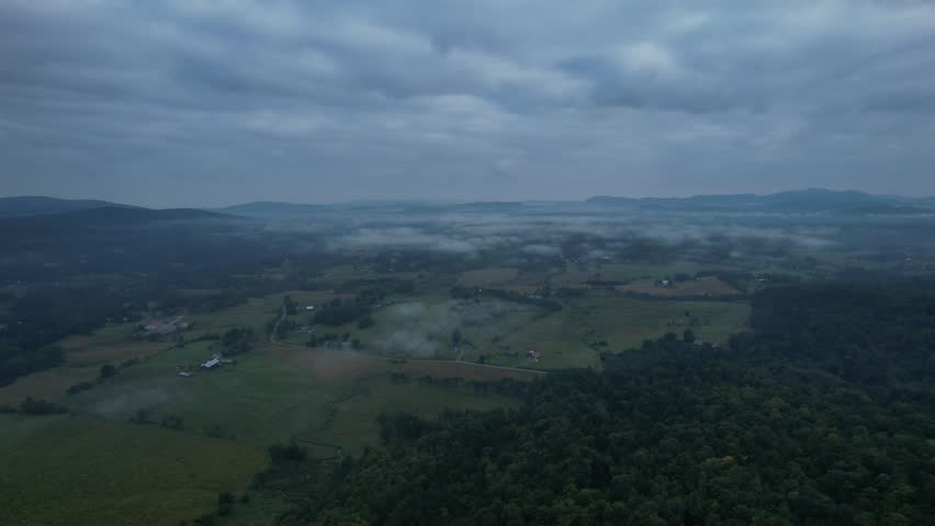 4k aerial Vermont green mountains and farm land during summer on a cloudy day