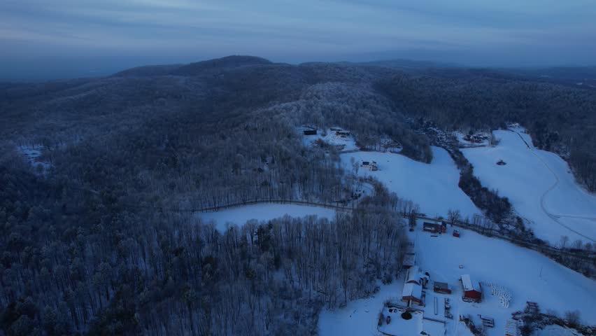 4k aerial Vermont winter landscape of mountains and homes amongst trees