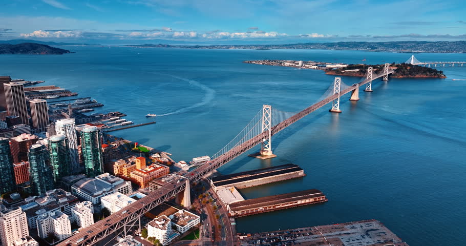 Approaching the Oakland Bay Bridge with hectic traffic on. Riverboat moves to the quay at backdrop. San Francisco, California, USA.