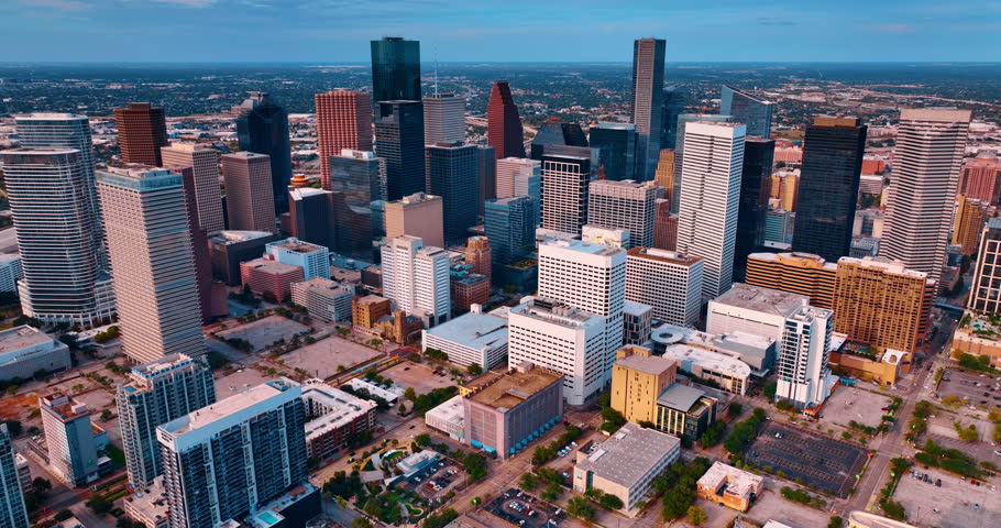Group of multi-storied buildings in the modern downtown Houston, Texas, USA. Drone descend in the city center at sunset.