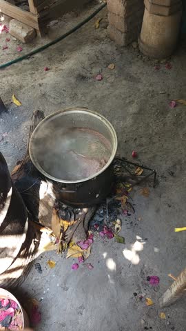 High angle view of pork meat simmering in broth inside a large metal pot