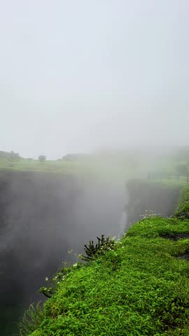 Hiwala Waterfall flows gracefully in stunning vertical 4K, surrounded by lush greenery, misty cliffs, and the refreshing beauty of nature in its purest form.