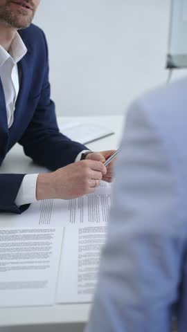 Business professionals engaging in a collaborative discussion, reviewing important documents and contracts, and working together on a project in an office setting