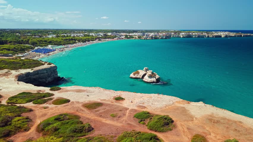 Drone shot of the iconic Le Due Sorelle Two Sisters sea stacks near the Torre dell Orso beach. The twin limestone rocks emerge from turquoise waters along the scenic Adriatic coast of Salento Puglia 