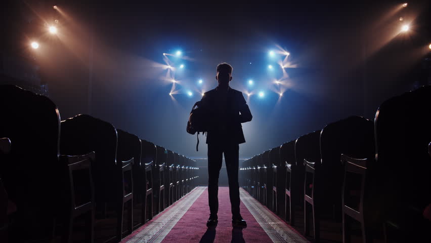 Cinematic Man Silhouette in Motorcycle Helmet Facing Stage Lights Zoom Out