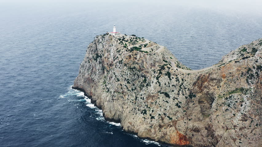 Aerial view of a lighthouse on a rock on the island of Mallorca in Spain. Tourist points of the Mediterranean in Europe.