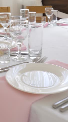 elegantly arranged restaurant banquet table. The setup features pristine white tablecloths, soft pink fabric napkins
