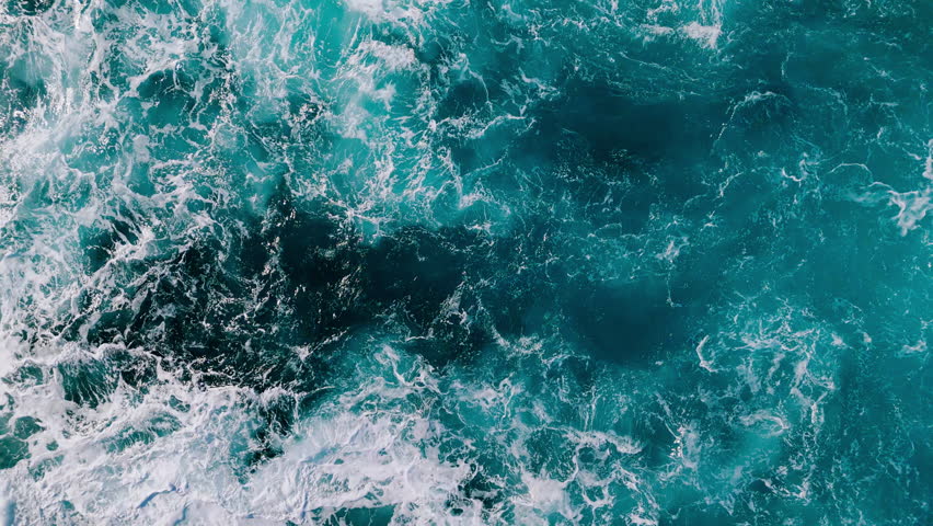 Open ocean surface with energetic waves and sea foam, constantly changing water patterns
