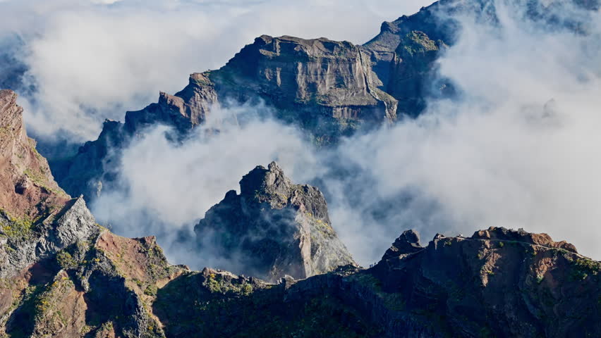 Cloud layers flowing over volcanic mountain formations near Pico do Arieiro, Madeira