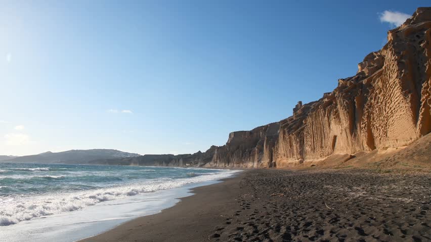 Santorini island, Greece. Yellow pumice volcanic cliffs on Vlichada beach. Blue sea and the blue sky at sunset. Summer landscape
