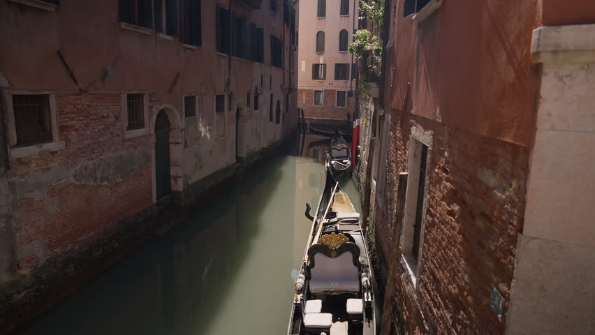 Gondola in historic Venice canal surrounded by old Italian buildings. Architecture, tourism, culture, travel and European heritage projects.