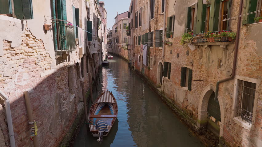 Boats in historic Venice canal surrounded by old Italian buildings. Architecture, tourism, culture, travel and European heritage projects.