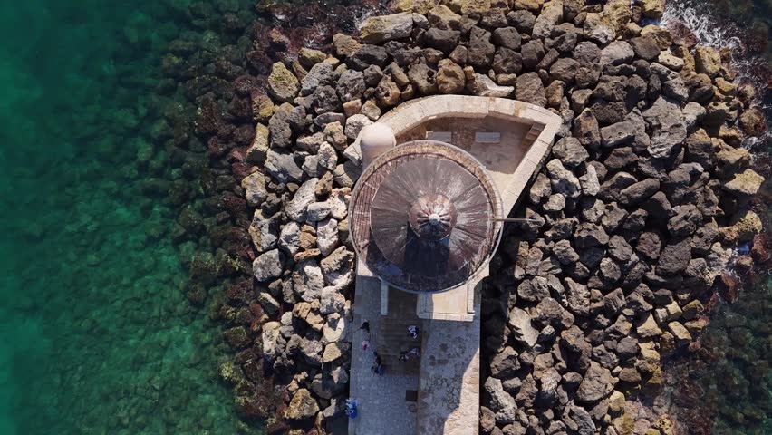 Aerial drone view of the iconic old Venetian harbor and lighthouse of Chania at sunny day, Crete, Greece. Cinematic 4K.