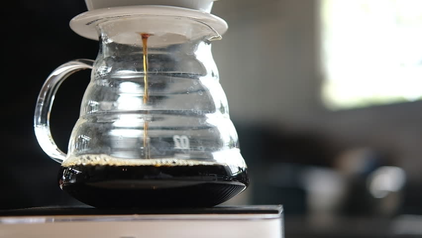 Cold brew coffee steeping in a glass pitcher with paper filter and coarse grounds, creating a refreshing beverage