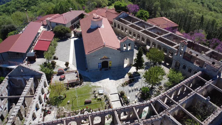 Wide angle aerial view of the historic Orthodox monastery on a mountain summit, focused on architecture, monastic culture and heritage tourism in Greece, Europe.