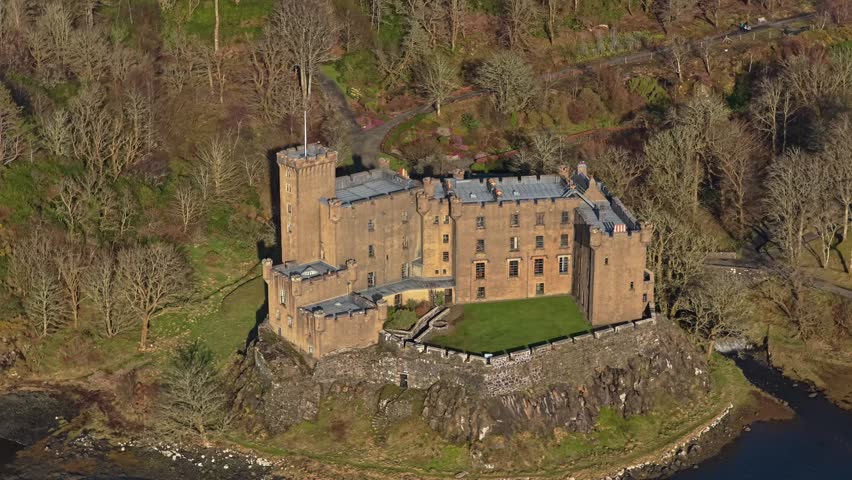 Aerial view of dunvegan castle and its gardens, a historic medieval fortress on the isle of skye in scotland, surrounded by woods
