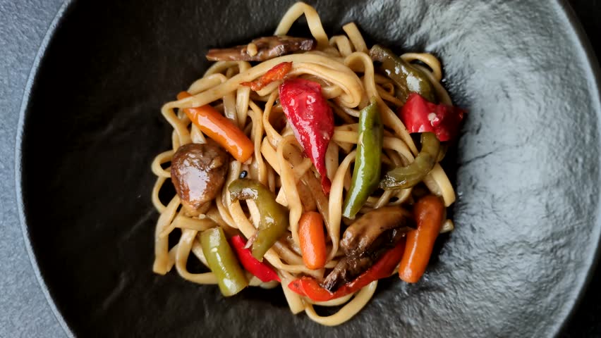 Asian food, noodles with vegetables, vegetarian dish with spicy sauce. Noodles with vegetables as a food background for your design